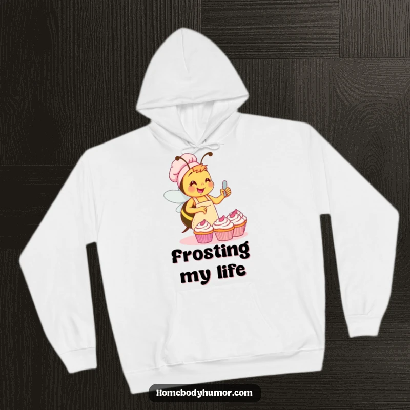 Funny Bee Hoodie: A busy little bee in an apron enthusiastically frosting cupcakes, offering warmth and funny charm. A superb funny gift.