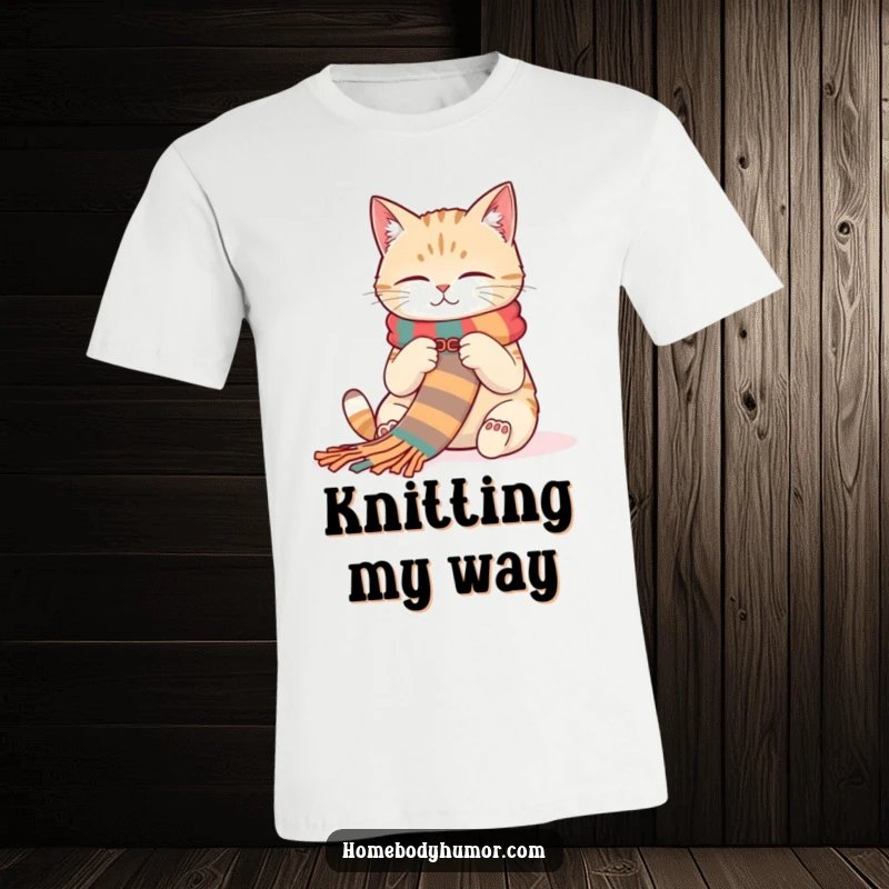 Funny Cat Knitting T-Shirt: A contented cat knitting a long, colorful scarf with focus and charm. A truly funny gift.